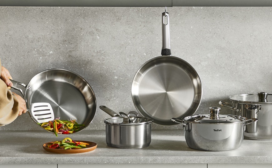 Panvica WOK Tefal Extreme E5291904, 28 cm nerez Sada kuchynského náčinia spolu s WOK panvicou je rozložená na kuchynskej linke.