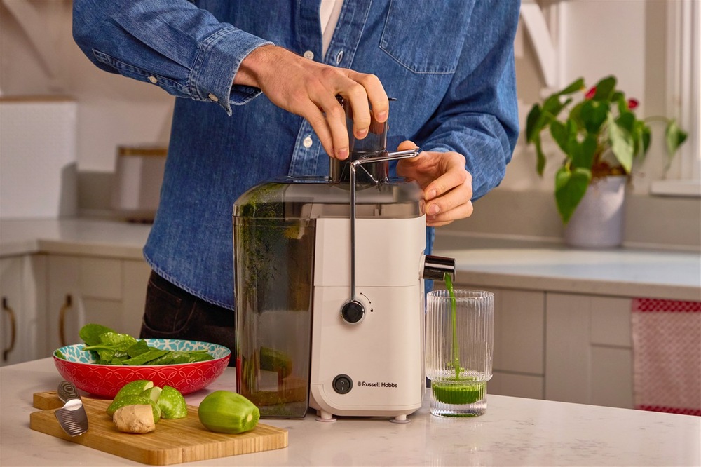 Muž vkladá ovocie do odšťavovača Russell Hobbs