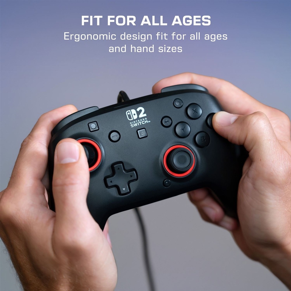 Gamepad Turtle Beach Rematch Wired, NS2 čierny Na obrázku je čierny drôtový gamepad Turtle Beach Rematch Wired držaný v rukách. Vidieť sú dve analógové páčky s červenými krúžkami, smerový kríž, hlavné tlačidlá a logo Nintendo Switch 2. Horný text upozorňuje na ergonomický tvar vhodný pre rôzne veľkosti rúk a hráčov všetkých vekových kategórií.