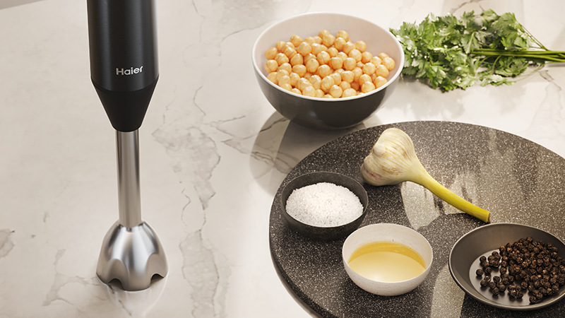 Ponorný mixér Haier I-Master Series 5 HHB5B2/1 011 čierny Ponorný mixér Haier HHB5B2/1 011 stojí na stole vedľa misiek s ingredienciami