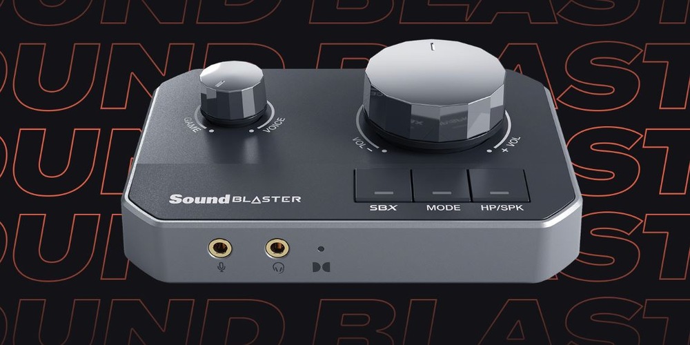 Zvuková karta Creative Sound Blaster G8 čierna Elegantný prevodník a zosilňovač s veľkými gombíkmi ovládania hlasitosti a tlačidlami označenými SBX, MODE a HP/SPK. Je vybavený dvoma výstupmi pre slúchadlá na pozadí s textom Sound Blaster.