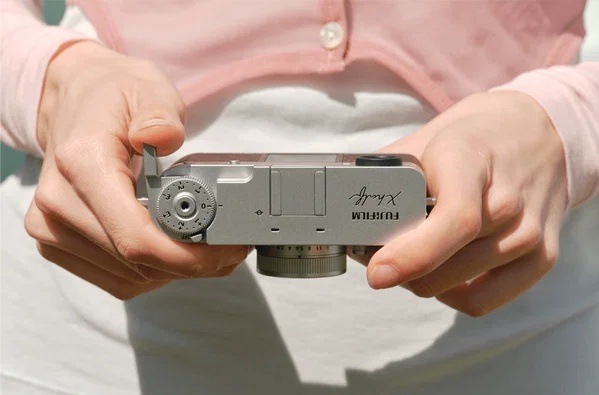 Digitálny fotoaparát Fujifilm X half čierny/sivý Horný pohľad na fotoaparát Fujifilm X half držaný oboma rukami s dobre dostupným voličom expozičných režimov