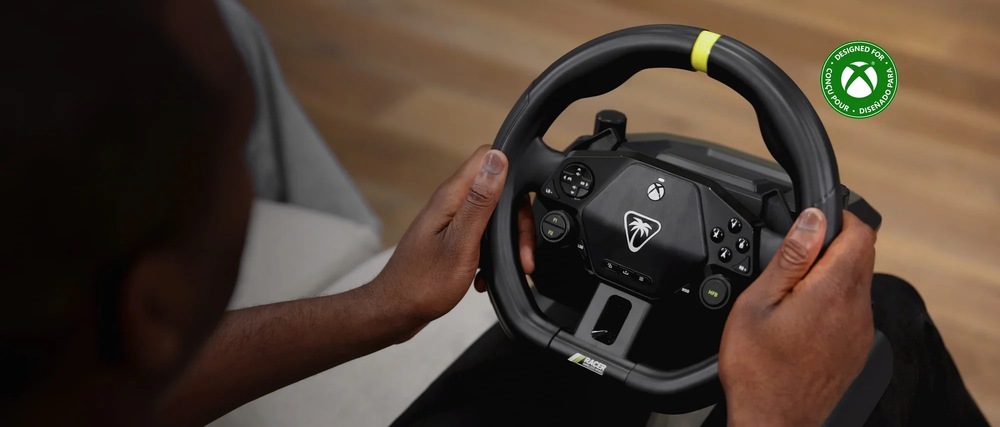 Volant Turtle Beach Racer - PC, Xbox One/Series čierny Záber na osobu držiacu v rukách veniec volantu Turtle Beach Racer. s drevenou podlahou v pozadí.