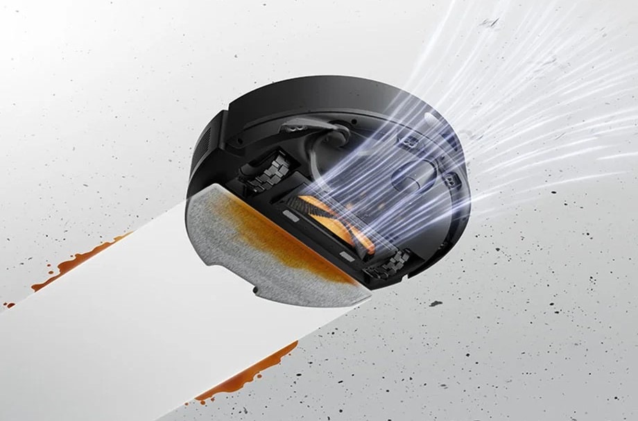 Robotický vysávač Dreame F20 Plus čierny Pohľad zospodu na robotický vysávač Dreame F20 Plus, ktorý nasáva nečistoty a zároveň za sebou necháva čistú vytretú podlahu.