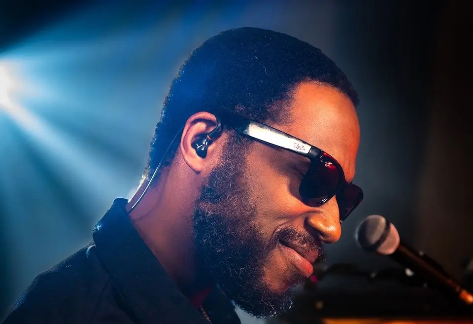 Slúchadlá Beyerdynamic DT 71 IE čierna Muž vo svetle reflektora s mikrofónom a so slúchadlami Beyerdynamic DT 70 IE