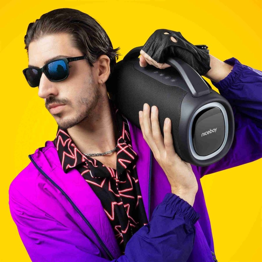 Prenosný reproduktor Niceboy Vulcan čierny Muž nesúci na ramene reproduktor Niceboy Vulcan s praktickým madlom
