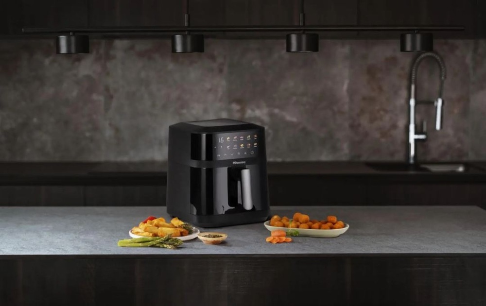 Fritéza teplovzdušná Hisense HAF1800DCD DUAL HEATER čierna zapnutá teplovzdušná fritéza Hisense HAF1800DCD DUAL HEATER na kuchynskej linke. Vedľa na tanieroch sú potraviny.