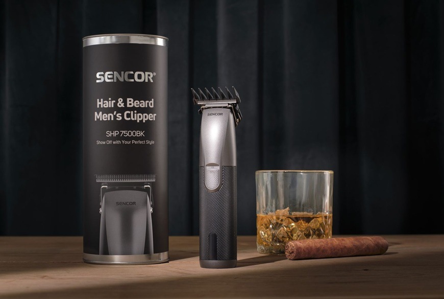 Zastrihávač vlasov Sencor SHP 7500BK čierny Štýlový zastrihávač vlasov Sencor SHP 7500BK je postavený vedľa cestovného púzdra. Whisky s cigarou dodávajú obrázku mužný podtext.