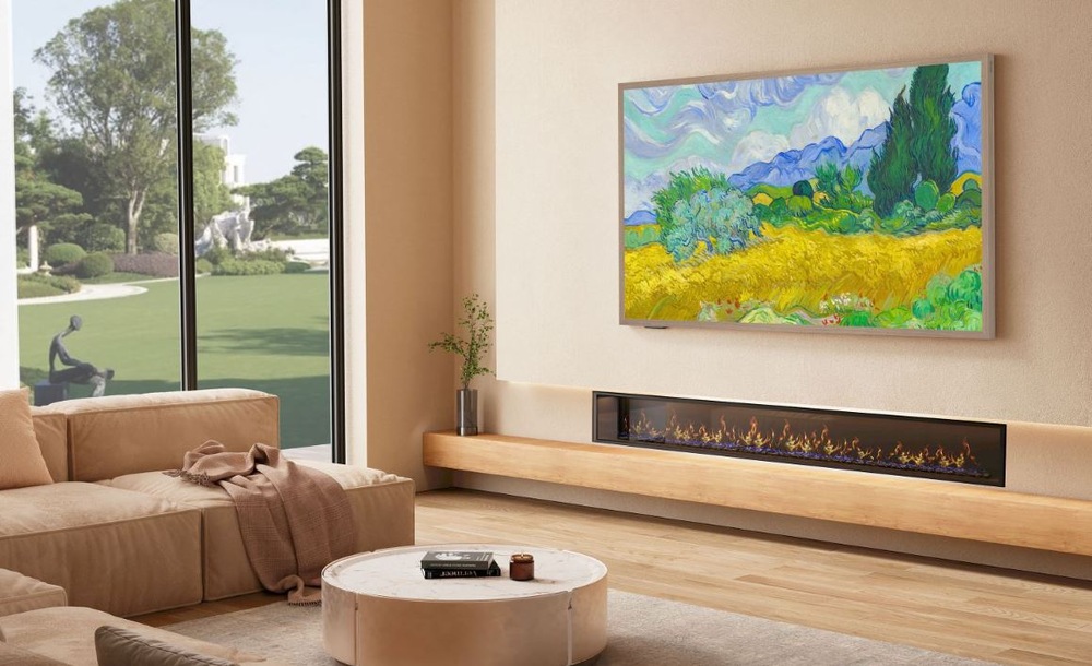 televízia Hisense visi v obyvacim izbe nad elektrickým krbom. Na tv je obraz príody v maľovanej podobe. Pred ňou je svetlý gauč. Izba má veľké okno do záhrady.