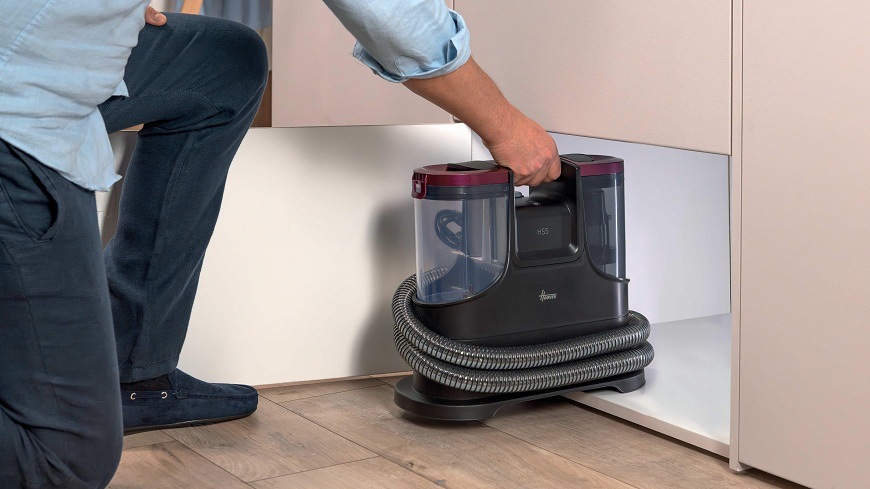 Tepovač kobercov Hoover HS530 011 čierny HS530 011 osoba zdvíha tepovač za vstavané madlo