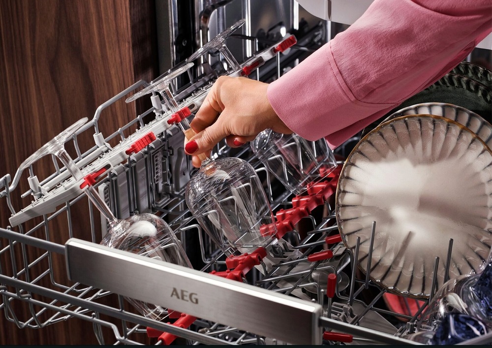 Vysunutý horný šuplík umývačky AEG radu 8000 CleaningPerformance. V šuplíku sú gumové protišmykové tŕne a držiaky, ktoré držia poháre so stopkou na svojom mieste.