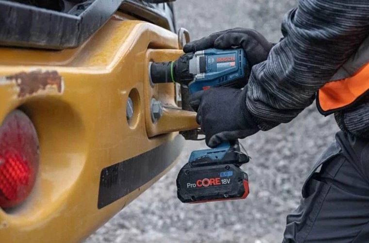 Doťahovák rázový Bosch Professional GDS 18V-350 (s baterií) Muž využíva náradie na uvoľnenie alebo utiahnutie matíc.