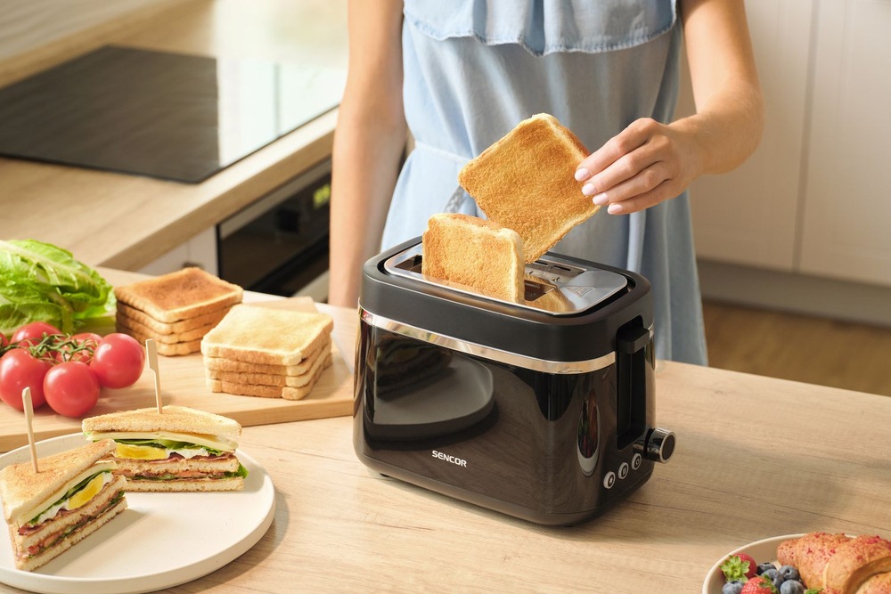 Hriankovač Sencor STS 2710BK čierny Príprava raňajok s hriankovačom Sencor STS 2710BK, z ktorého žena vyberá hotové toasty.