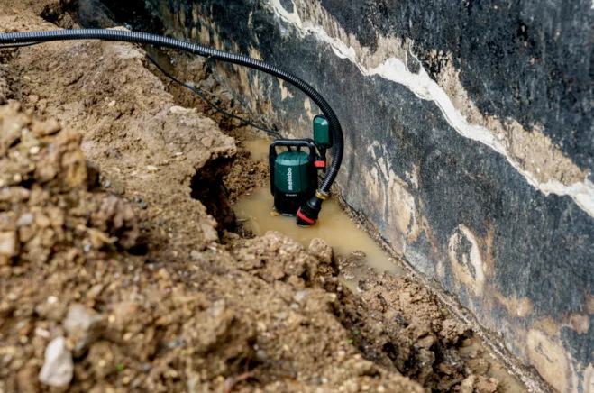 Ponorné čerpadlo Metabo SP 120-35 S pri čerpaní vody z výkopu pri základoch budovy.