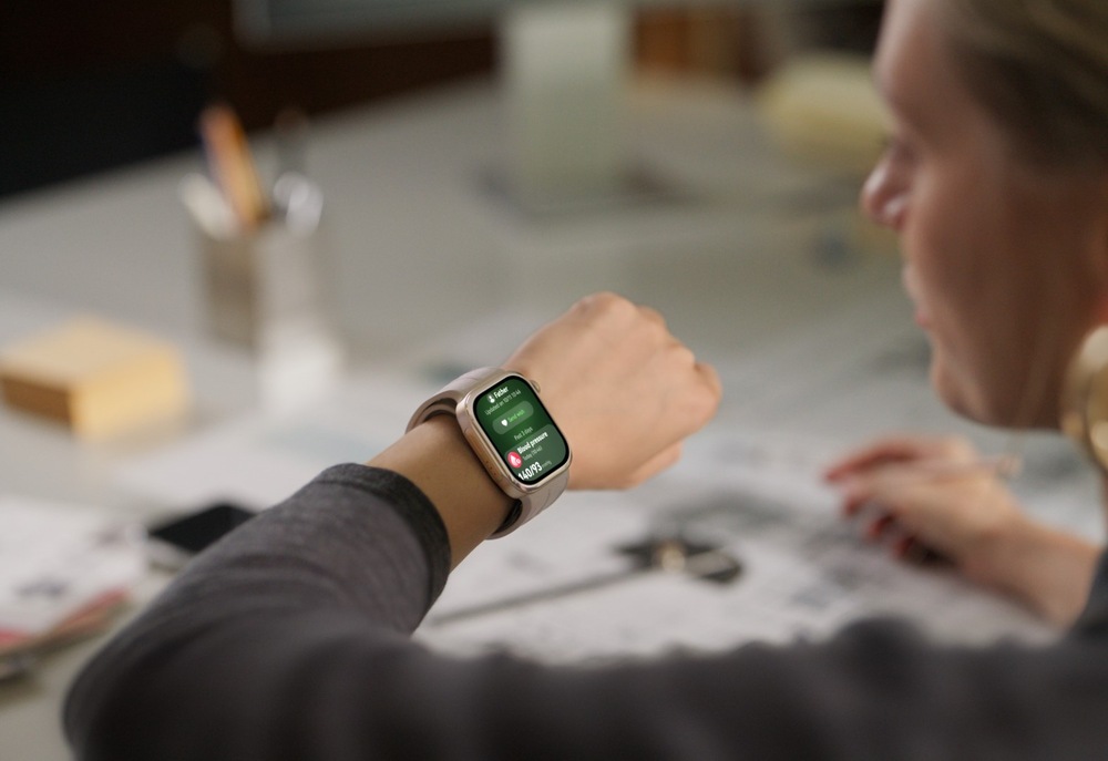 Inteligentné hodinky Huawei Watch D3 čierne Žena pri pracovnom stole sleduje inteligentné hodinky na zápästí, ktorých displej zobrazuje prehľad krvného tlaku s nameranou hodnotou
