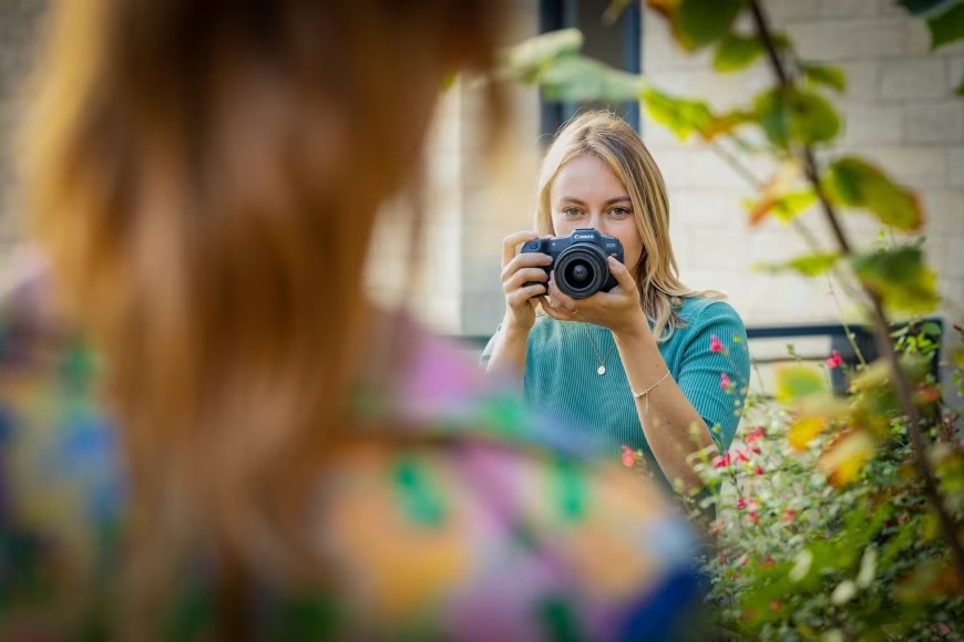 Žena fotografujúca portrét modelky pomocou fotoaparátu Canon EOS R8