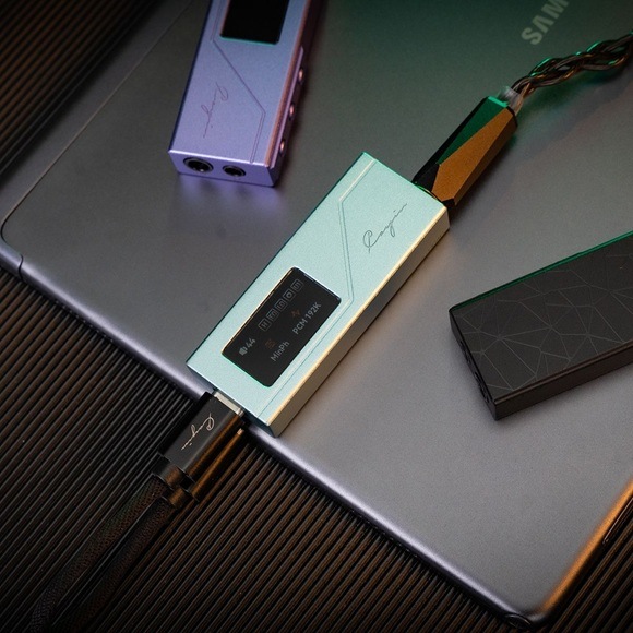 Slúchadlový zosilňovač Cayin RU3 čierny Detail obrázku zosilňovača umiestneného na notebooku.