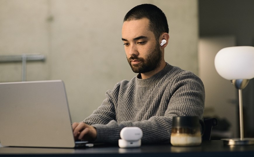 Slúchadlá AKG N5 Hybrid čierna Muž pracujúci na notebooku má v uchu slúchadlo AKG N5 Hybrid