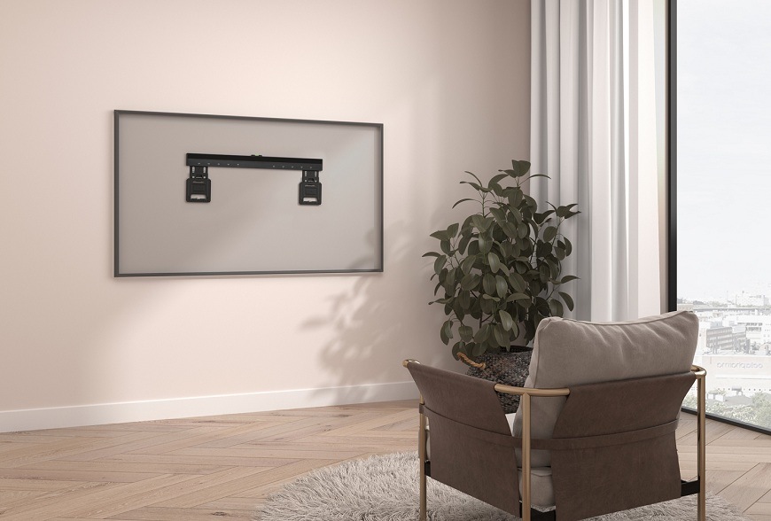 Fixný ultra tenký TV držiak GoGEN na stene v minimalistickom interiéri s izbovou rastlinou