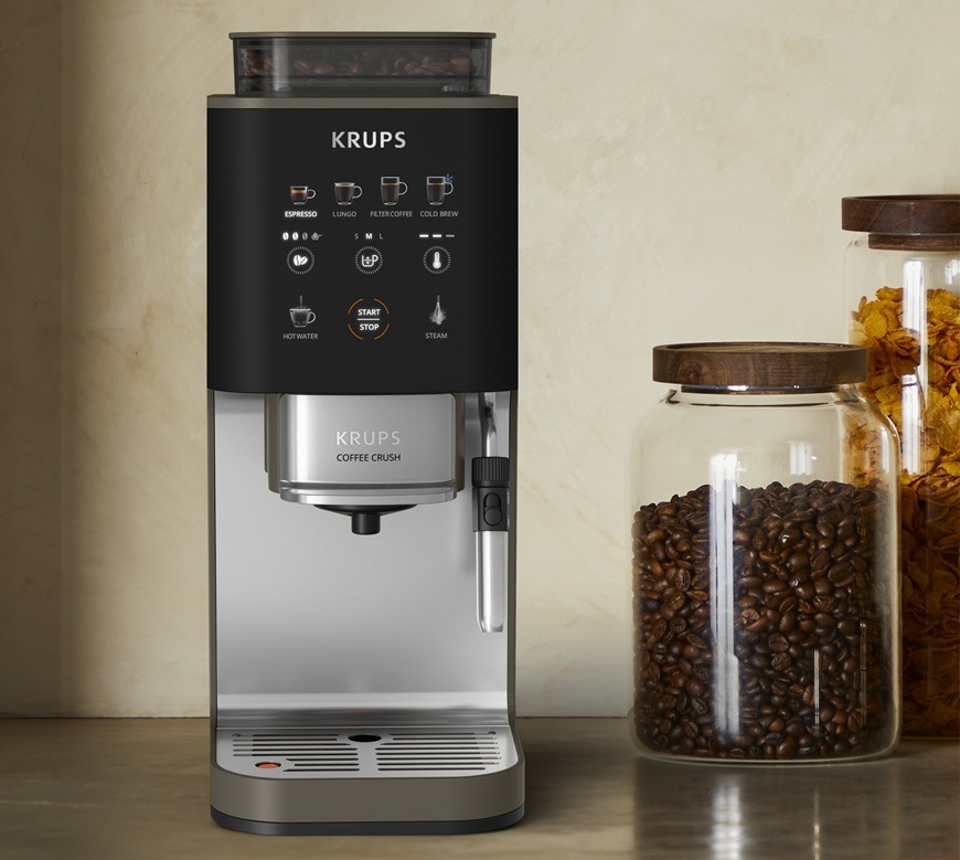 Automatický kávovar Krups Coffee Crush Experience SA403BE0 sivý/hnedý Predný pohľad na automatický kávovar Krups SA403BE0 Coffee Crush Experience. Vedľa neho sú na stole položené sklenené dózy.