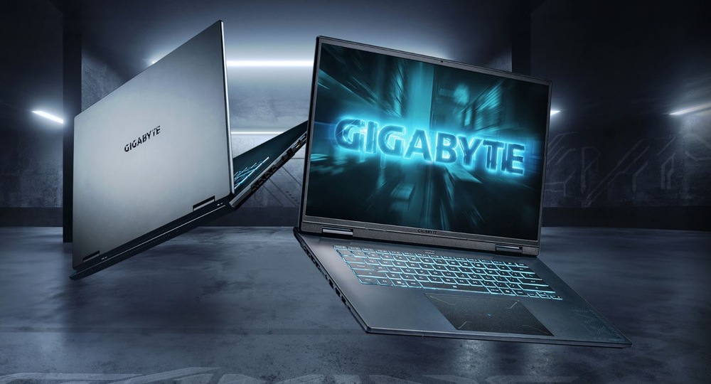 V temnej miestnosti sa vznášajú dva elegantné notebooky s modrým nápisom Gigabyte. Žiarivá atmosféra navodzuje dojem high-tech a futuristického prostredia.