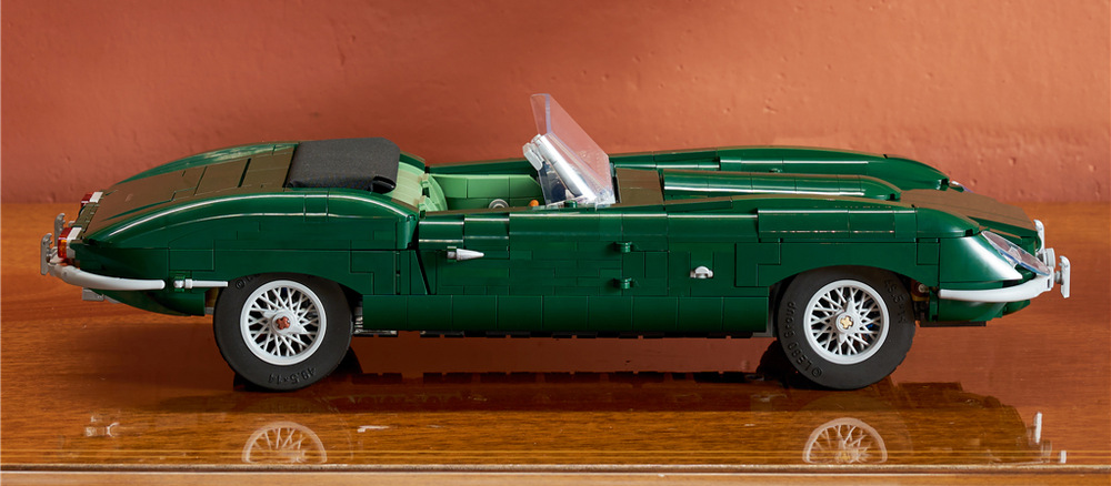 Jaguar E-Type vyniká charakteristickými proporciami, zelenou karosériou a drôtenými ráfikmi v klasickom štýle.