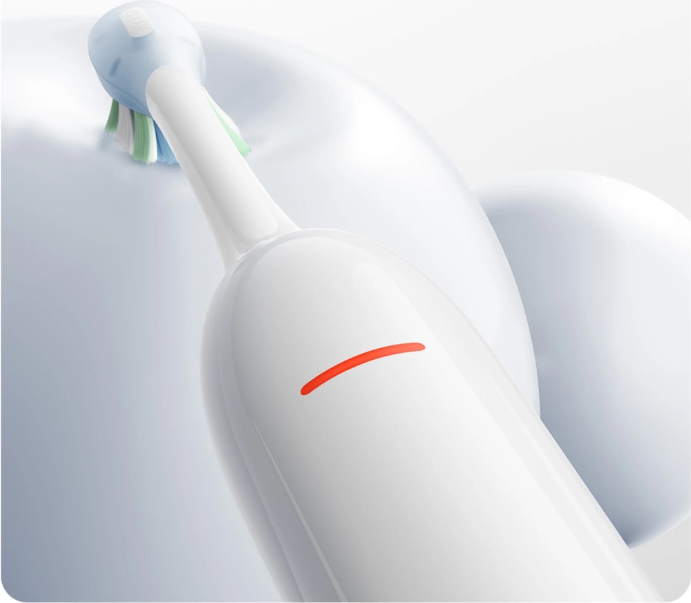 Zubná kefka Xiaomi Mijia MES613 Smart Servo-oscillation Pro EU White biely Detail elektrickej zubnej kefky Xiaomi MES613 priloženej k povrchu zuba s rozsvietenou signalizáciou prílišného tlaku