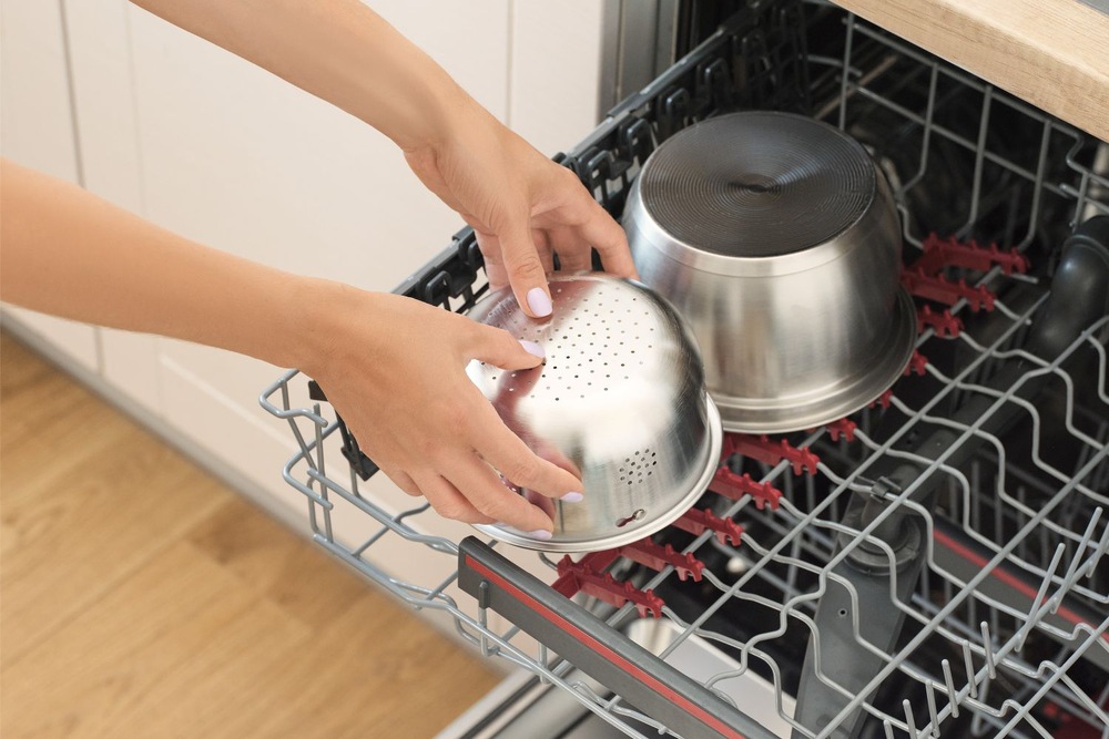 Ryžovar Sencor SRM 2000WH Low Carb Žena dáva nerezový košík z ryžovaru do umývačky riadu