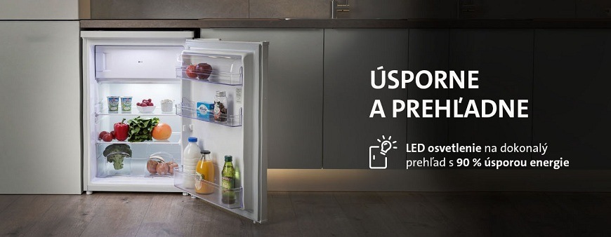 Otvorená malá chladnička ETA s LED osvetlením v modernej kuchyni. Text zdôrazňuje úspornosť a prehľadnosť vďaka LED technológii s 90% úsporou energie. Chladnička je naplnená čerstvými potravinami