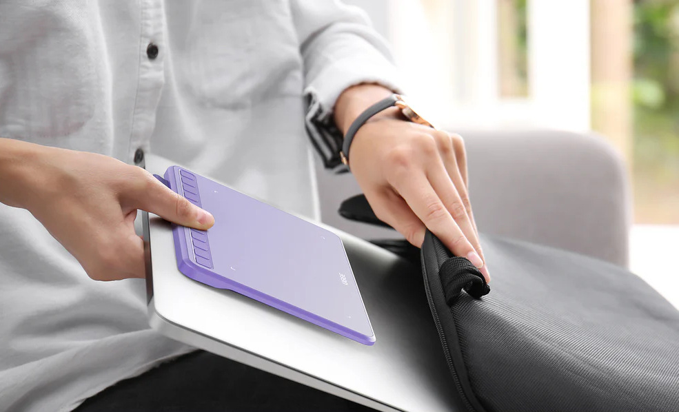Grafický tablet UGEE S640 béžový Muž vkladá laptop a tablet UGEE S640 do batohu