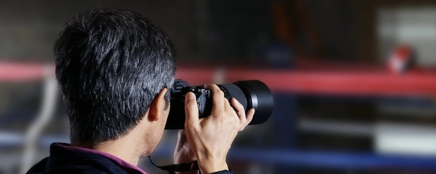 Digitálny fotoaparát Sony Alpha 7 III + 28-70 OSS II čierny Pohľad šikmo zo strany na muža fotografujúceho pomocou Sony Alpha 7 III