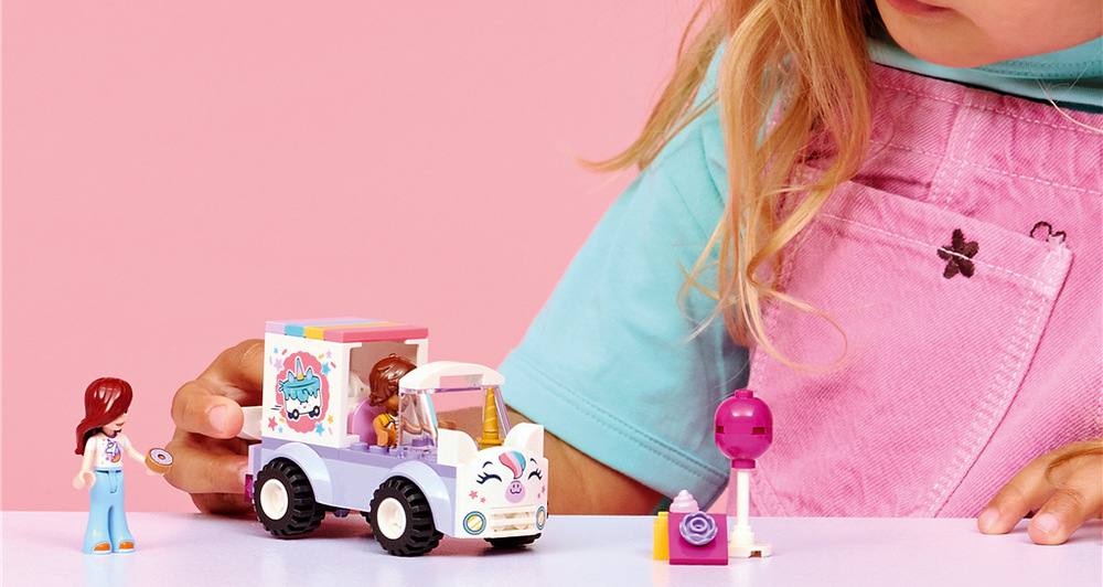 Stavebnica LEGO® Friends 42675 Jednorožie donáškové auto s tortou Paisley a Lea dávajú deťom možnosť rozdeliť si role a vymýšľať vlastné príbehy počas narodeninovej donášky.