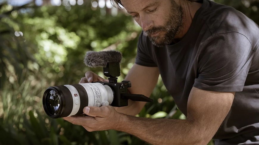 Digitálny fotoaparát Sony Alpha 6700 + 16-50 mm f/3.5-5.6 II čierny Muž natáčajúci z ruky s teleobjektívom a fotoaparátom Sony Alpha 6700 s päťosou stabilizáciou