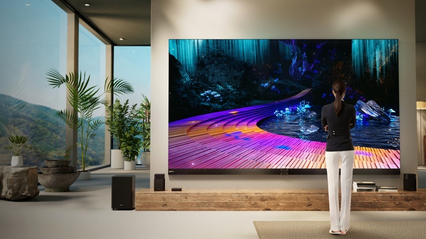Televízor Hisense 136MX televízia Hisense 136MX umiestnená v modernom obývacom priestore zobrazuje výrazne farebnú scénu s vysokým kontrastom a detailmi. Postava stojaca pred obrazovkou podčiarkuje impozantnú veľkosť displeja.