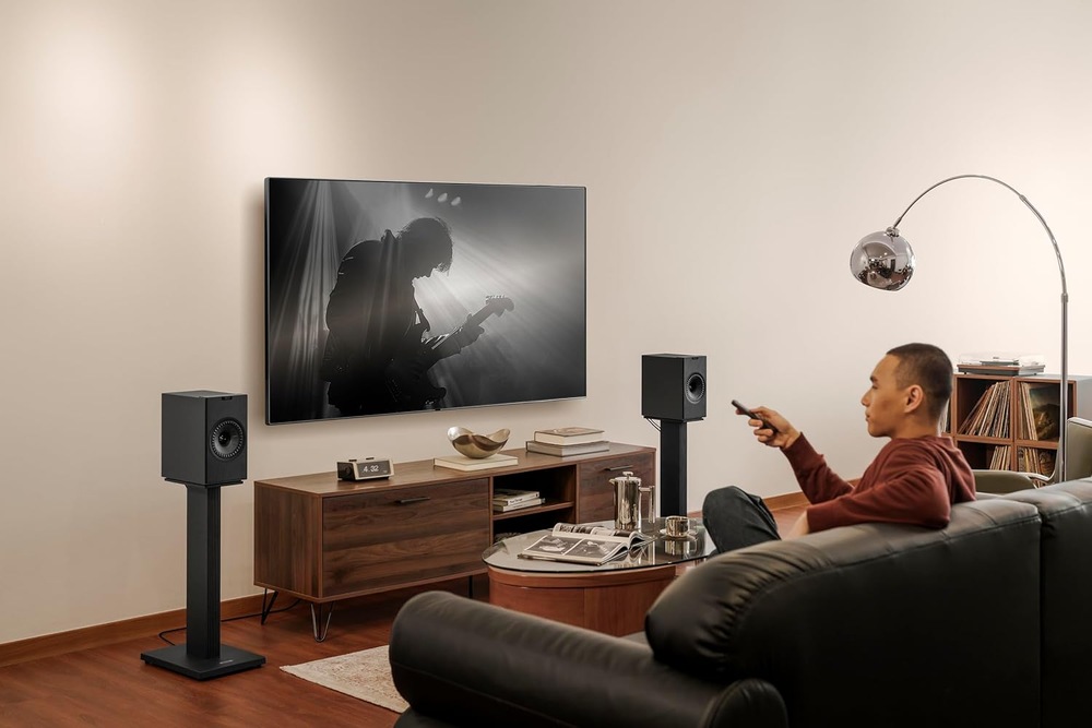 Reproduktory KEF Coda W (2 ks) čierne Muž sleduje koncert na televízii doplnenej po stranách o reproduktory