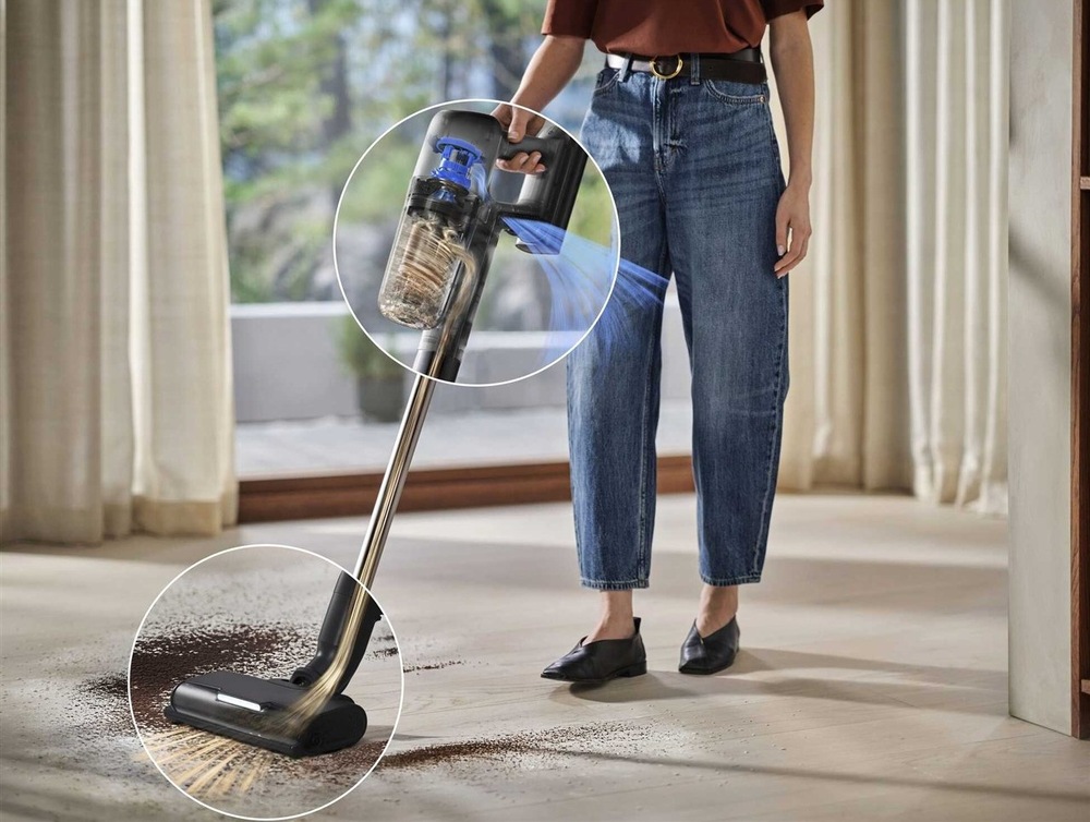 Tyčový vysávač Electrolux 700 Animal EP72AB21UG sivý Žena vysáva vysávačom Electrolux koberec v obývačke.