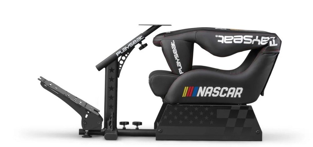 Bočný pohľad na čierne sedadlo závodného simulátora s tematikou NASCAR. Sedadlo má logá a farebné pruhy, má nastaviteľnú základňu pedálov a robustný rám.