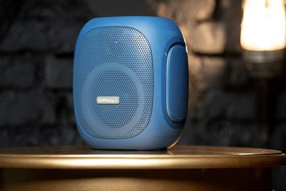 Prenosný reproduktor Concept SoundJoy BR5037 modrý Modrý reproduktor Concept SoundJoy BR5037 umiestnený na stolíku počas domáceho počúvania