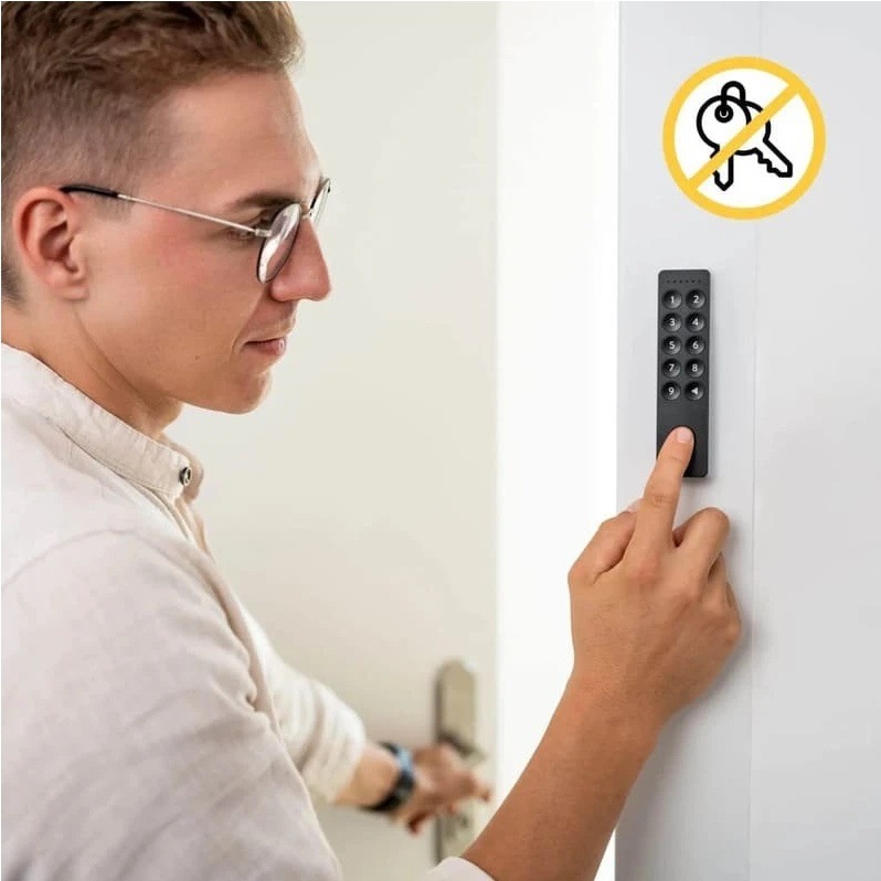 Klávesnica pre smart zámok Nuki Keypad 2 čierna Muž zadávajúci kód na Nuki Keypad 2.0 na odomknutie dverí bez fyzického kľúča.