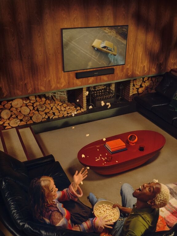 Dvojica žien s popcornom sa baví pri filme so zvukom zo soundbaru Marshall Heston 60″ width=