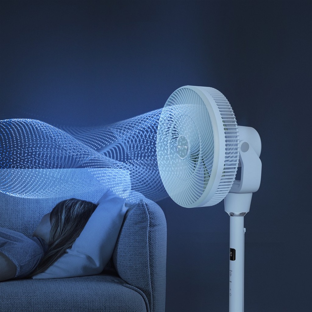 Ventilátor stojanový Rowenta QV5050F0 Turbo Silence Compact 3D Nomad biely Žena odpočívajúca na pohovke s ventilátorom Rowenta ofukujúcim ju v noci.