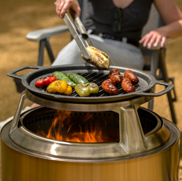 Grilovací rošt Solo Stove Yukon 27” Grilovanie klobás a zeleniny na liatinovom rošte Solo Stove Yukon 27 nad ohňom v ohnisku