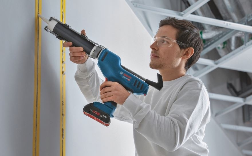 Lis Bosch Professional GCG 18V-310 (bez baterie) Muž opravuje praskliny v stene pomocou vytlačovacej pištole Bosch Professional GCG 18V-310