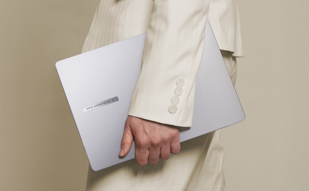 Osoba nesúca notebook Asus ExpertBook P3 G2 pod pažou