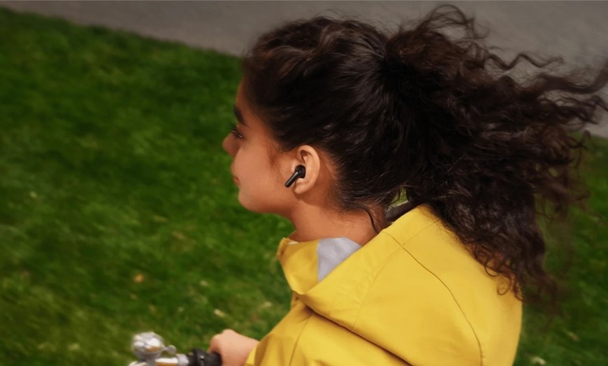 Slúchadlá Xiaomi REDMI Buds 8 Active modrá Žena idúca na bicykli má v uchu slúchadlo Buds 8 Active s potlačením hluku pri mikrofónoch