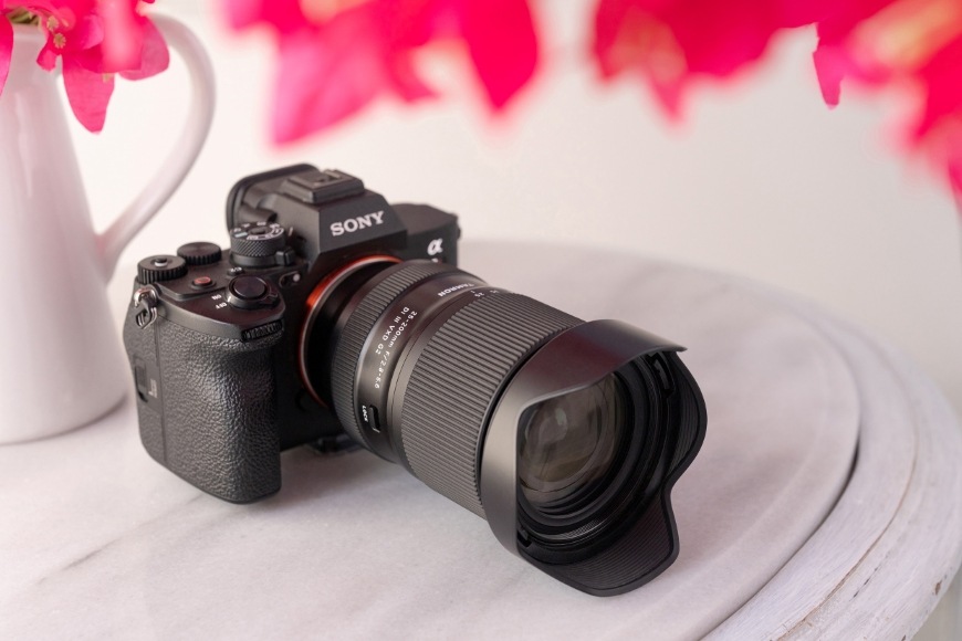 Objektív Tamron 25-200 mm f/2.8-5.6 Di III VXD G2 (Sony FE) čierny Pohľad spredu na fotoaparát Sony a objektív Tamron 25–200 mm f/2.8–5.6 Di III VXD G2 so slnečnou clonou