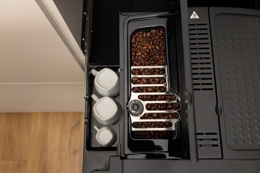 Espresso Gorenje G800 CM4G8BG čierna Na obrázku je vrchný pohľad s detailom na dávkovač plný kávových zŕn. Za kávovarom Gorenje CM4G8BG je priestor na odkladanie hrnčekov.
