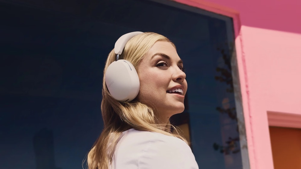 Slúchadlá SONOS Ace Ultra čierna Usmievavá žena v meste s oblúkovými slúchadlami