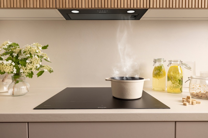 Na indukčnej varnej doske Gorenje GI6443BSCWF sa varí jedlo. Odsávač aj varná doska má funkciu HoodSync, takže sa zaplo automatické odsávanie pary.