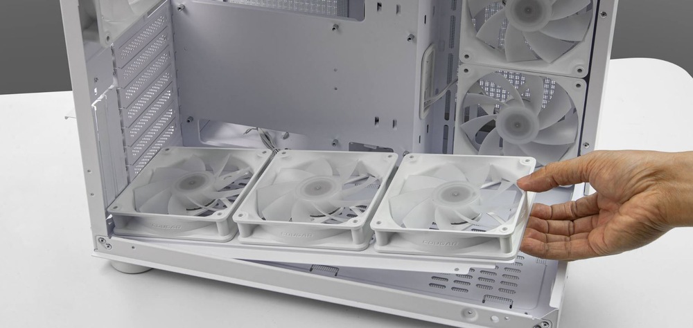 Case Cougar FV150 RGB Dual-Chamber čierna Osoba upravuje držiak ventilátorov vo vnútri otvorenej počítačovej skrine. Interiér je čistý a usporiadaný, je vidieť niekoľko ventilátorov na svojich miestach, čo naznačuje zameranie na účinnosť chladenia.